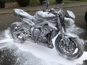 Mono motorcycles using snow foam to prepare a motorcycle for detailing.